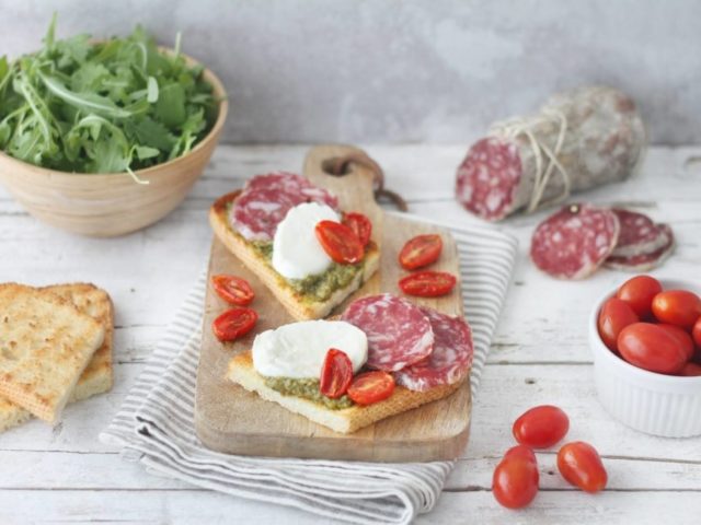 BRUSCHETTA AL PESTO DI RUCOLA CON MOZZARELLA DI BUFALA, POMODORINI CONFIT E SALAME FELINO IGP 